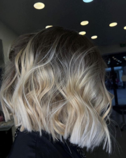 Wavy long bob haircut with blonde highlights.