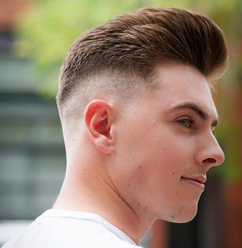 Medium length men's haircut with a bald fade