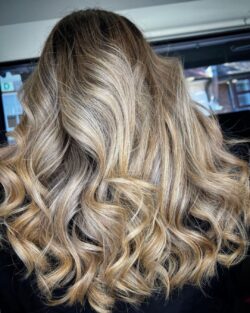 Long blonde hair styled with textured curls.
